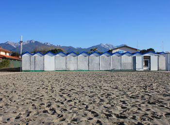 Built structure on beach against clear blue sky