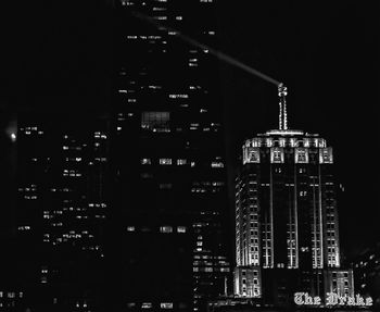 Illuminated buildings in city against sky at night