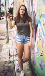 Portrait of woman standing by colorful wall