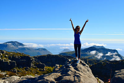 Full length of woman standing on mountain against sky