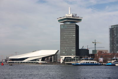 Tower by sea against sky in city