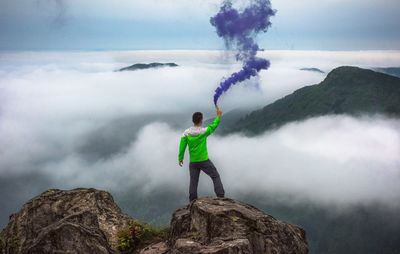Full length of woman standing on mountain against sky