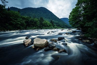 Scenic view of waterfall against sky