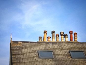 Low angle view of roof with chimneys against sky