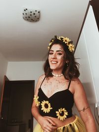 Portrait of a smiling young woman standing against white wall