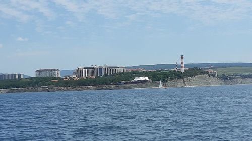 Buildings by sea against sky in city