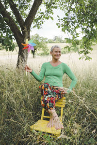 Portrait of smiling young woman sitting on field