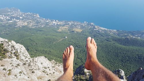 Low section of man relaxing against mountain