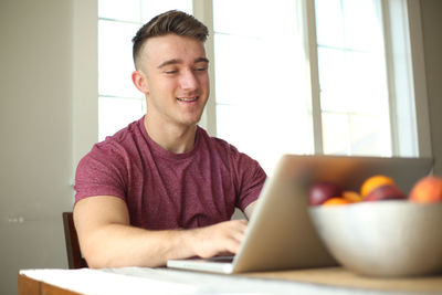 Young man using mobile phone at home