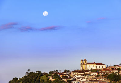 Colonial style church on the mountain with moonlight in the background in the city of ouro preto