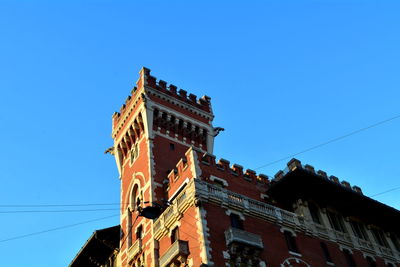 Low angle view of old building against clear blue sky