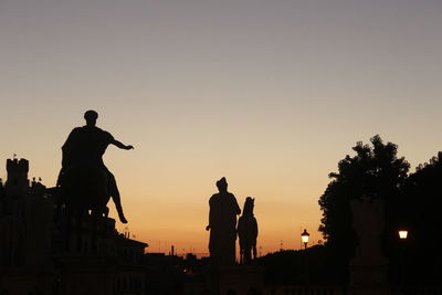 Silhouette man standing against clear sky at dusk