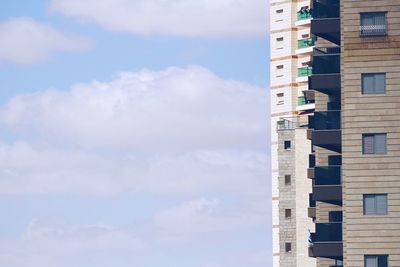 Low angle view of buildings against cloudy sky