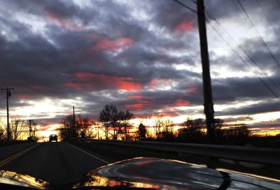 Road passing through dramatic sky at sunset