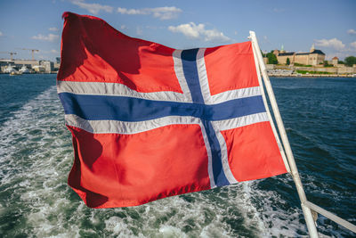 Close-up of flag against boat in sea