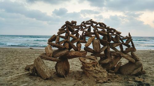 Close-up of stack on sand at beach against sky