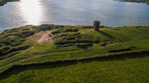 High angle view of grass by sea against sky