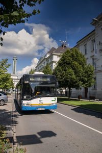 Cars on street in city against sky