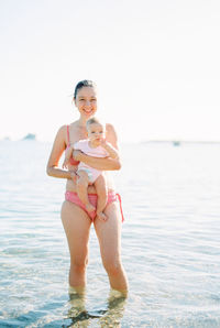 Portrait of young woman in bikini while swimming in sea