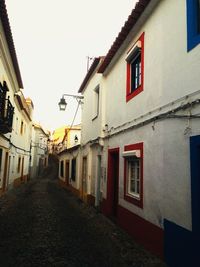 Empty alley amidst buildings in city