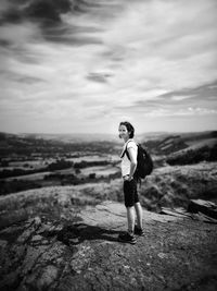 Full length of woman standing on mountain against cloudy sky