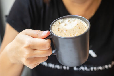 Midsection of woman holding coffee