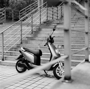 Bicycle parked on street against fence in city