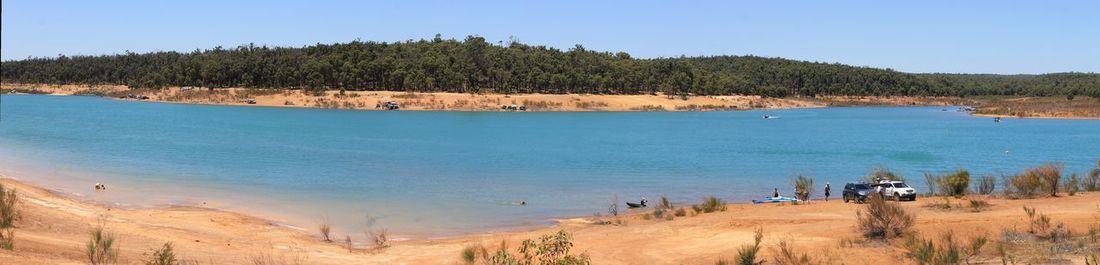 Panoramic view of beach against clear blue sky