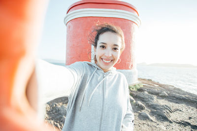 Portrait of young woman standing at beach