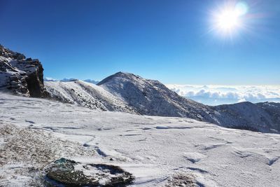 Scenic view of snowcapped mountains against clear blue sky