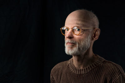 Man wearing eyeglasses against black background