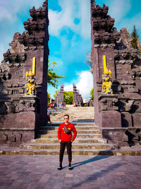 Full length of woman standing by historic building against sky