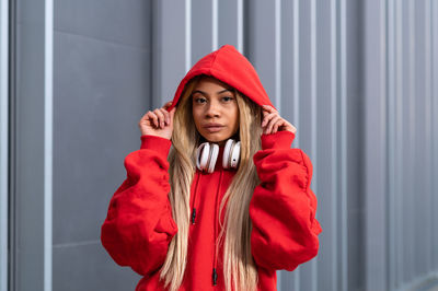 Cheerful african american woman with long blonde hair wearing sportswear and wearing headphones