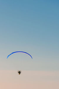 Person paragliding against clear blue sky