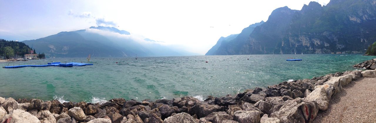 water, nautical vessel, sea, transportation, mode of transport, scenics, boat, tranquil scene, tranquility, beauty in nature, rock - object, mountain, nature, rock formation, sky, shore, beach, travel, incidental people, idyllic