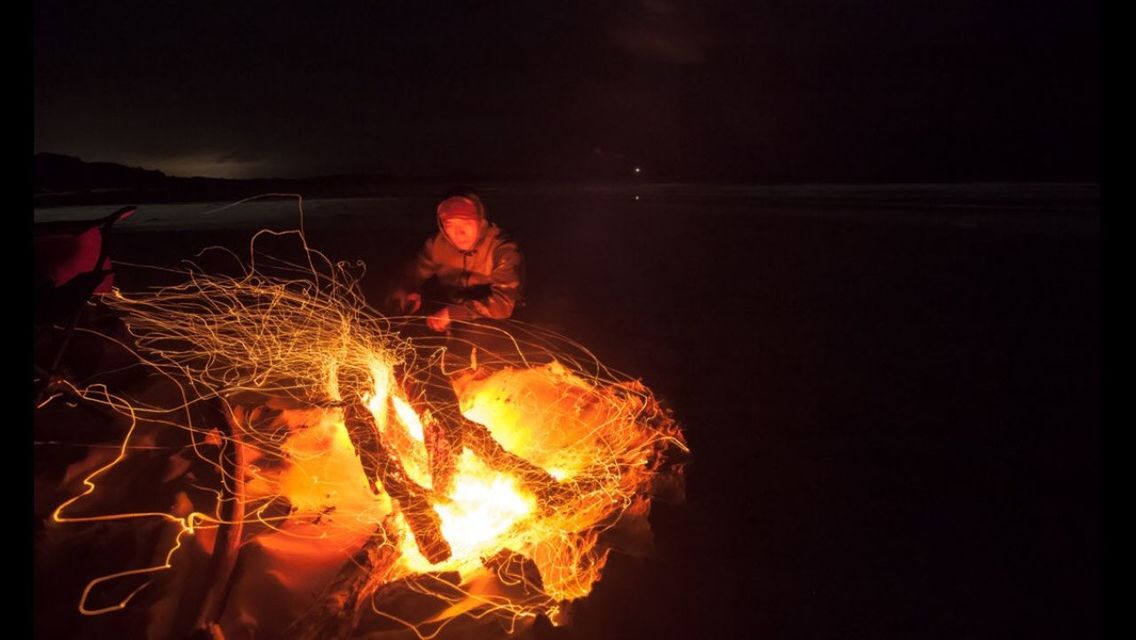 MIDSECTION OF WOMAN WITH ILLUMINATED FIRE AT NIGHT