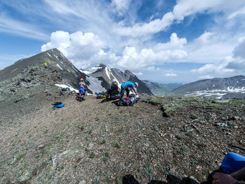 People on mountain range against sky