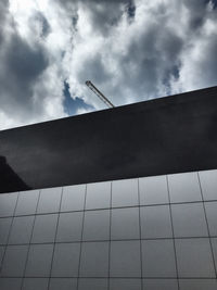 Low angle view of fence against cloudy sky