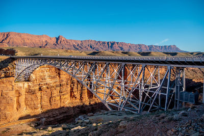 Arch bridge over mountains against blue sky