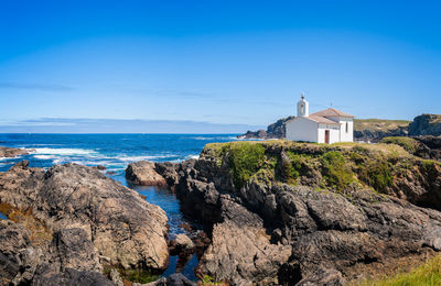 Panoramic view of sea and buildings against blue sky