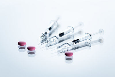 Syringes and tablets on white background, covid-19 corona virus vaccine and medicine