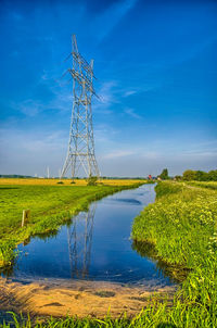 Electricity pylon on field against sky