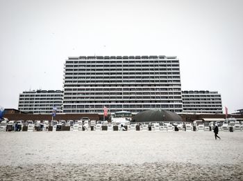 People walking on beach against clear sky