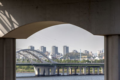 Bridge over han river against sky in city seen through columns