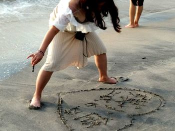 Low section of women walking on beach