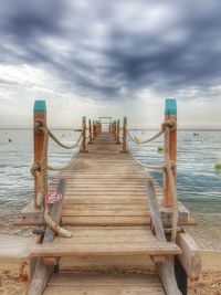 Wooden pier on sea against sky