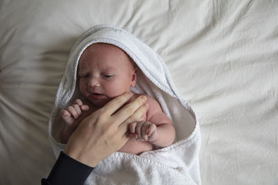 Portrait of cute baby girl lying on bed