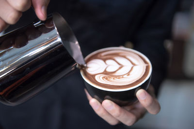 Cropped image of hand holding coffee cup