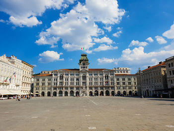 Buildings in town against cloudy sky