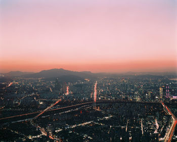 Aerial view of city lit up at sunset